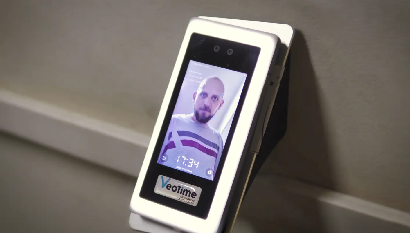 Reloj biométrico registrando una fichada con reconocimiento facial.